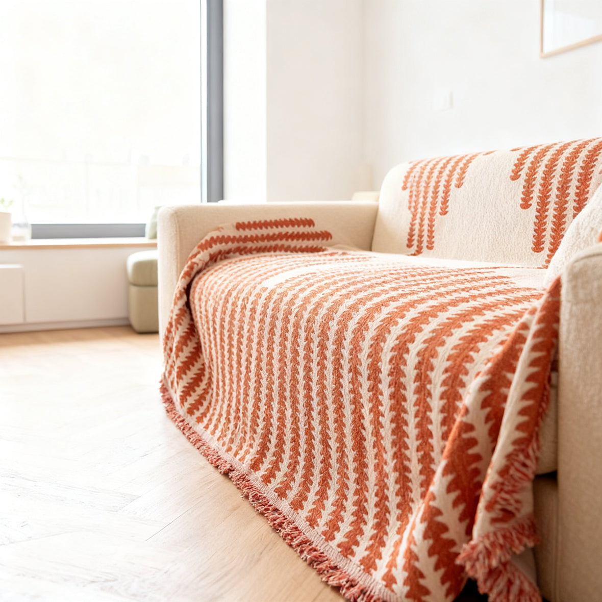 Wende-Sofabezug aus Chenille in Terrakotta-Weiß mit Fransenkante über einem Sofa